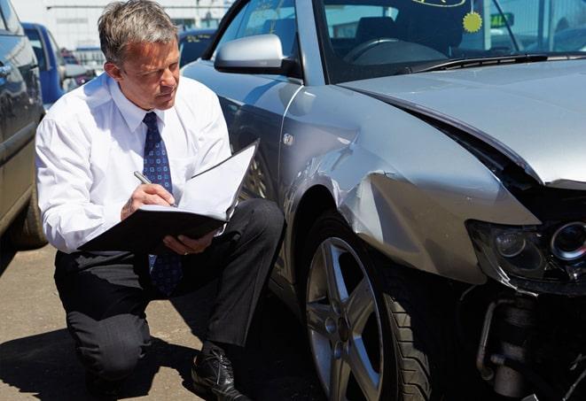 insurance agent explaining policy options to client with car in background